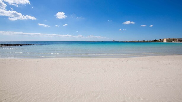 A beach with clear blue water and a sandy shore. - 1890 Bilo Conchiglia Blu (Porto Cesareo)