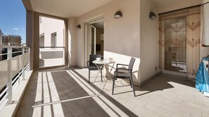 A balcony with a table and chairs, a view of the street, and a building in the background. - 1866 Stella Bianca Luxury Suite (Lecce)
