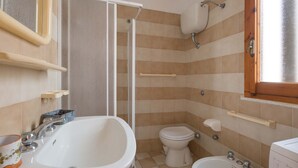 A bathroom with a bathtub, a toilet, and a sink. - 1892 Casa Di Ronzino (Melendugno)