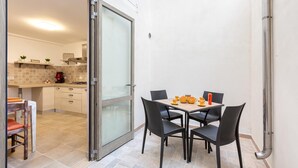Cocina compacta con comedor, que cuenta con un ventanal corredero a un balcón.