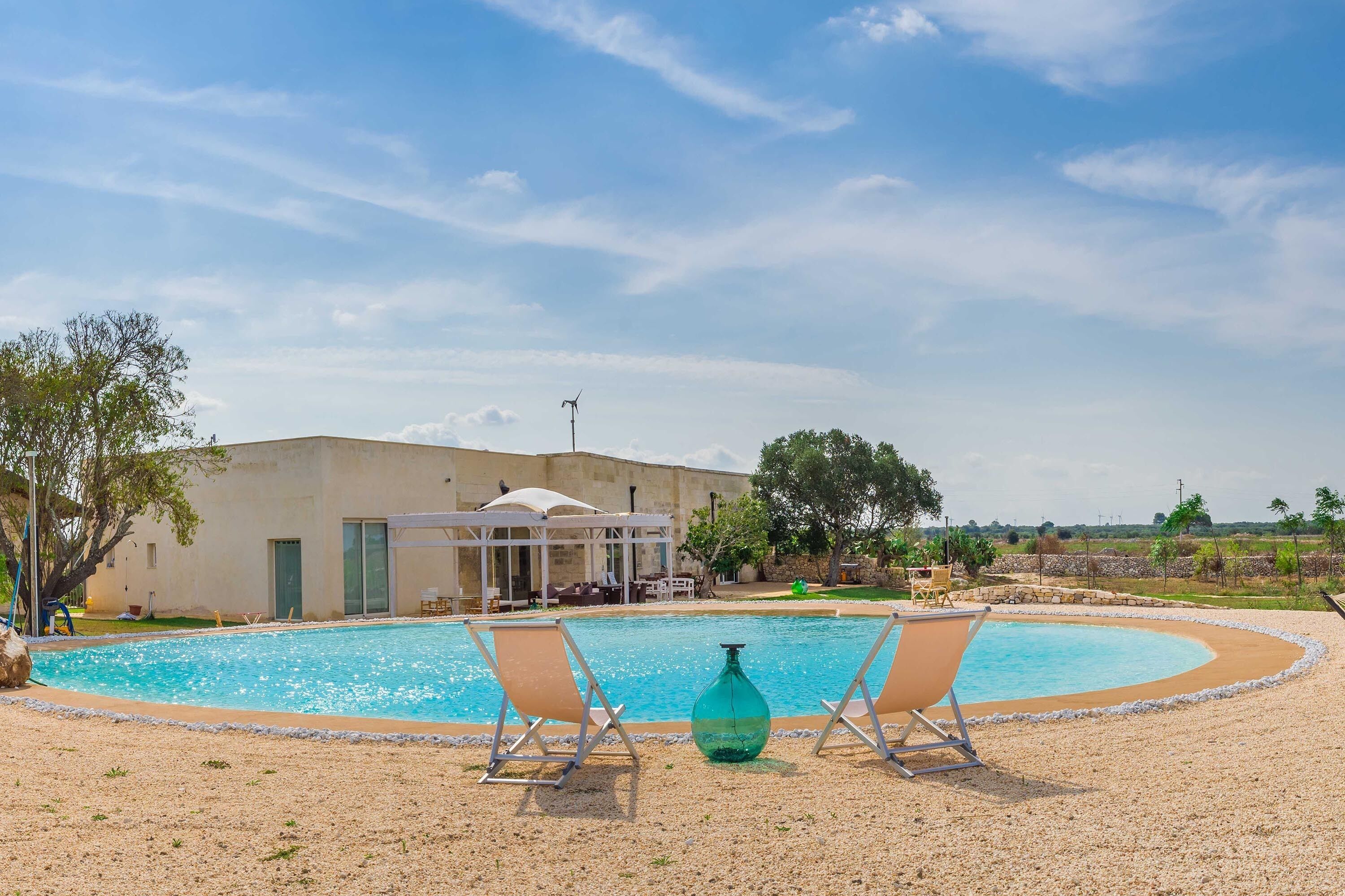 Ein Swimmingpool mit zwei Liegestühlen und einer großen, grünen Flasche.