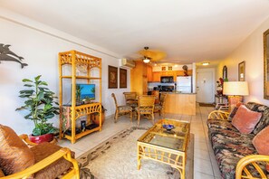 Una sala de estar con sofá, mesa de centro y sillas, un comedor con mesa y sillas, y una cocina equipada.