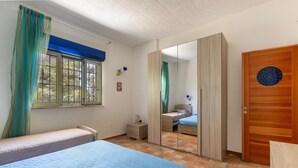 A bedroom with two beds, a wardrobe, a mirror, and a window with curtains. - 1906 Villa Sara (Porto Cesareo)