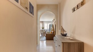 A hallway with a wooden dresser, a decorative wall piece, and a small ship model on the dresser. - 1861 La Casa di Giulia (Otranto)