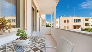A balcony with a tiled floor, a potted plant, and a chair. - 1861 La Casa di Giulia (Otranto)