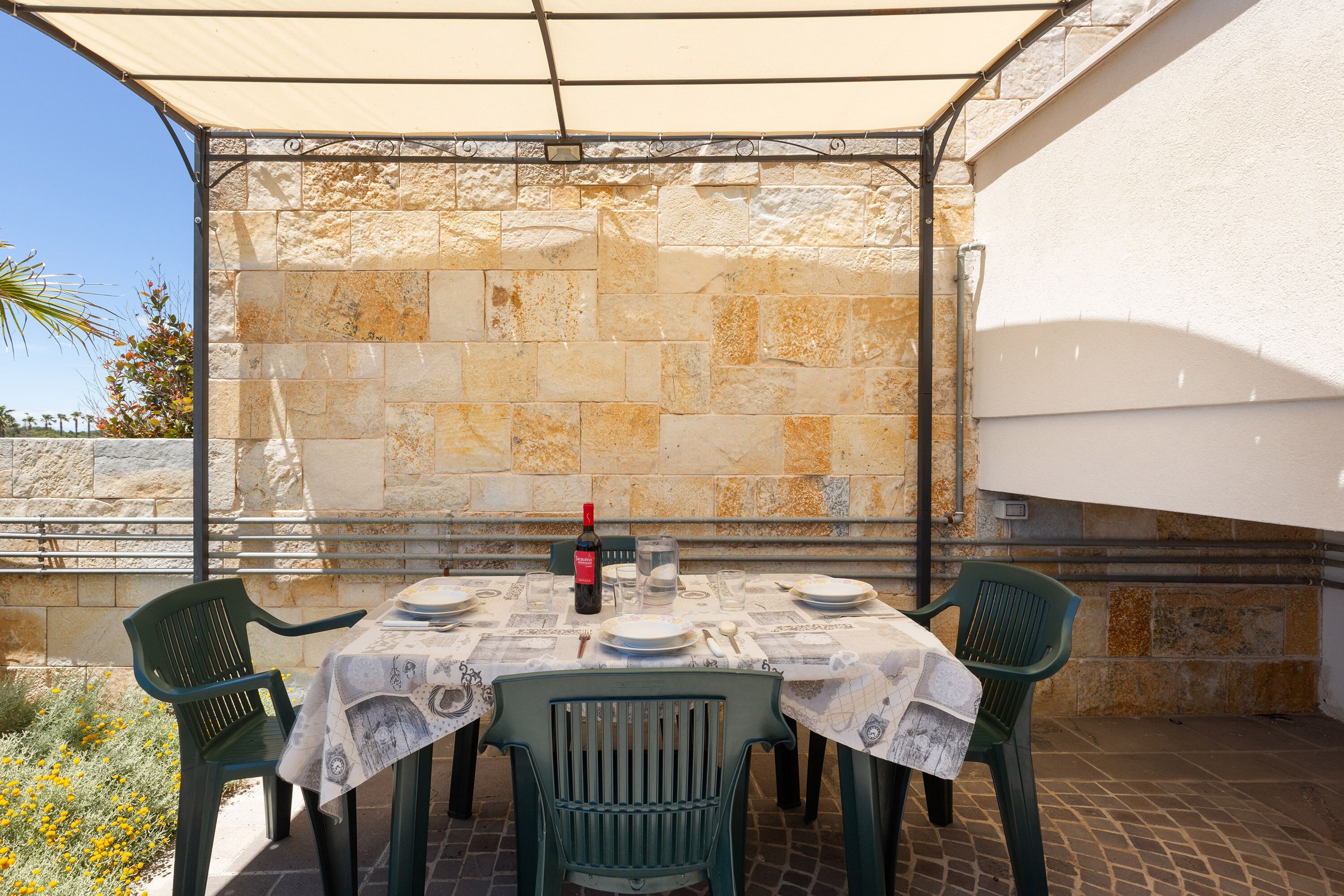 A table set for four with a bottle of wine, plates, and cutlery.