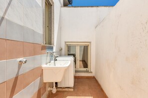 A small bathroom with a sink, mirror, and window.