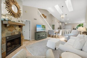 Cozy living area with a fireplace, comfortable seating, and a modern kitchen.