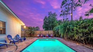 A backyard with a swimming pool, lounge chairs, and a wooden fence. - Comfy Mayo Retreat: Pool & Close to Beach (Jacksonville Beach)
