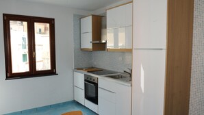 Una cocina pequeña con ventana, estufa y lavabo.