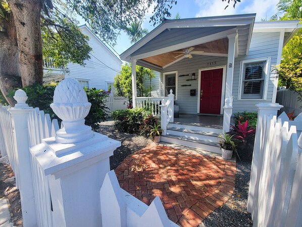 A house with a porch, a red door, and a mailbox.