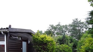 Un petit bâtiment en bois sombre, sur lequel est apposée une pancarte indiquant « à louer » et le numéro 82.