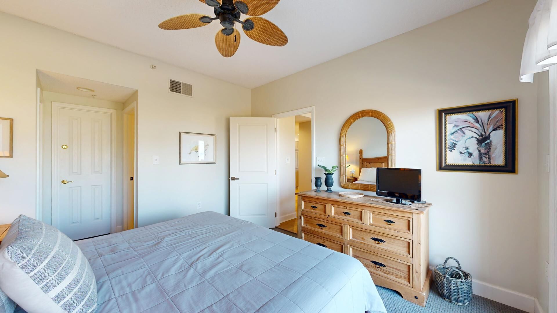 Ein Schlafzimmer mit Bett, Kommode, Fernseher und Bildern.