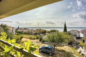 Un quartiere residenziale con case, un'auto parcheggiata e vista sul mare.
