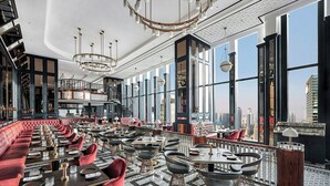 Un restaurante espacioso con techos altos, ventanas amplias y un diseño interior moderno.