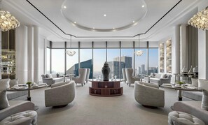 A spacious lobby with a central round table, comfortable seating, large windows offering city views, and elegant lighting fixtures. - The Langham, Jakarta (Jakarta)