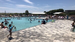 Een zwembadgedeelte met meerdere zwembaden, ligbedden en parasols.