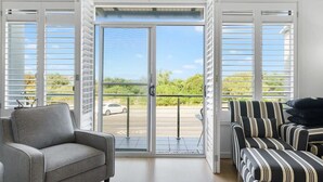 A modern living room with a grey sofa, a striped sofa, and a grey armchair.