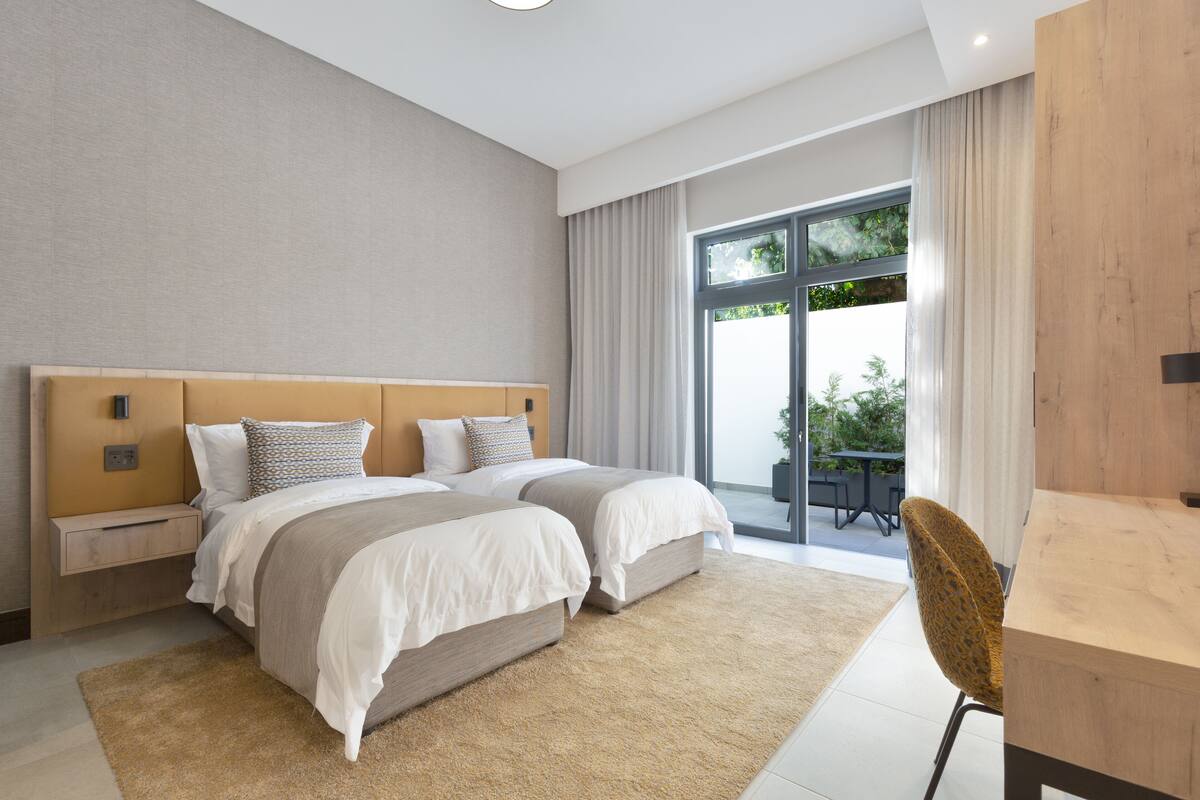 Un dormitorio moderno con una cama grande, un escritorio y vistas al exterior.