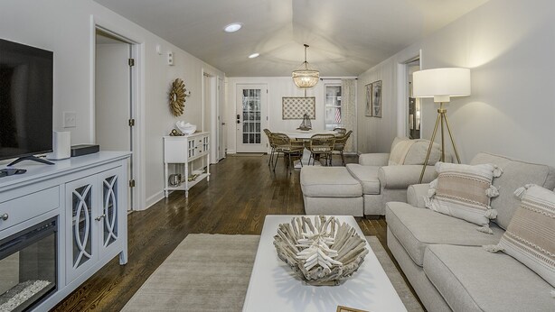 A spacious living room with a television, a dining area with a chandelier, and a cozy seating area with a lamp. - 3 BD/2 BA  Pet Friendly Summerwind! Amenity Access included! Close to Beaches, Pools, Dining & Golf! (Seabrook Island)