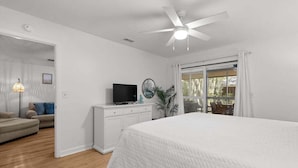 A bedroom with a bed, a television on a dresser, a ceiling fan, and a view through a window. - 3 BD/2 BA  Pet Friendly Summerwind! Amenity Access included! Close to Beaches, Pools, Dining & Golf! (Seabrook Island)