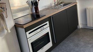 A kitchen with a built-in oven, a stainless steel range hood, and a window providing a view of the outdoors.