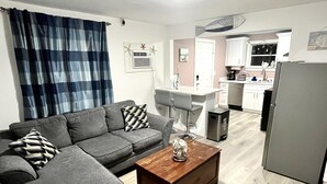A living room with a grey sofa, a wooden coffee table, and a blue plaid curtain. - Beachy Paradise (Indian Rocks Beach)