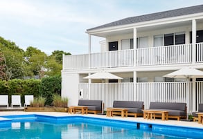 Una piscina al aire libre de temporada, sombrillas