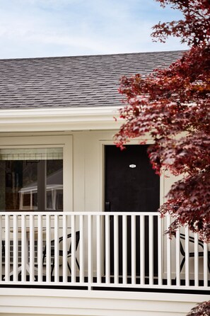 A building with a white exterior, a black door, and a white railing.