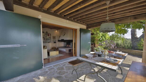 An outdoor dining area with stone flooring, a wooden ceiling, and a view of the garden. - MY TUSCANY VILLA: Absolute privacy, between pine and olive trees (Palaia)