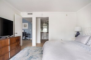A bedroom with a bed, a TV, a dresser, and a desk with a chair. - The Blue Octopus - 1br King Bed Condo (Fort Lauderdale)