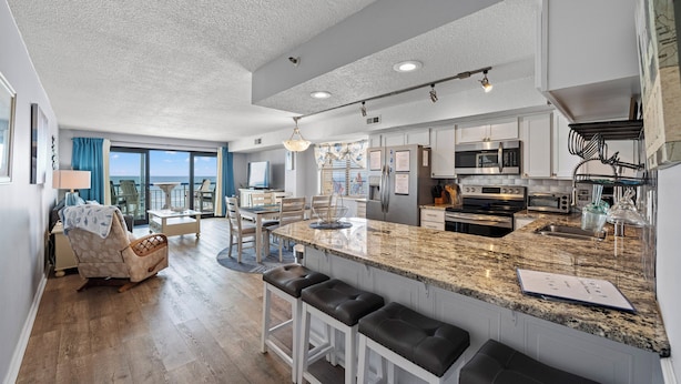 A modern kitchen with a large island, built-in appliances, and a view to the outside.