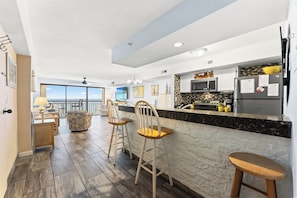 Cozinha moderna com área de bar, espaço de jantar com vista e ventilador de teto.