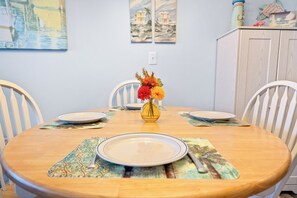 Ein Esstisch mit Platzsets, Tellern und einer Blumenvase.