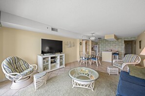 Relax in a comfortable seating area with a sofa, armchairs, and a dining table.
