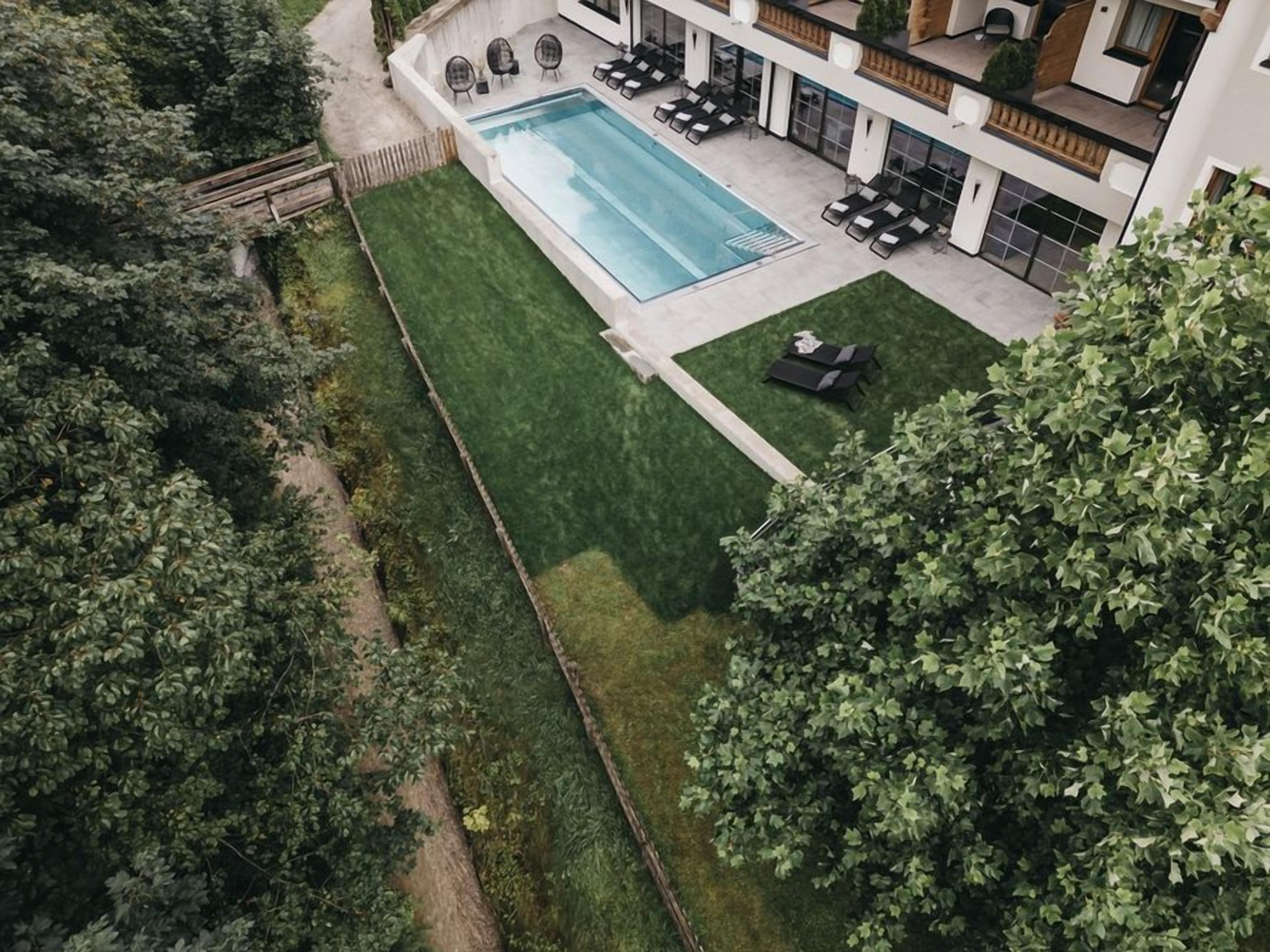 A rooftop pool with a clear view of the surrounding greenery and a modern building structure.