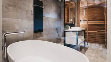 Ein modernes Badezimmer mit freistehender Badewanne, einer gläsernen Dusche und einem Holzbadezimmer-Möbel.