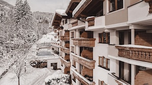 Un hotel de varios pisos con balcones de madera y un paisaje cubierto de nieve.
