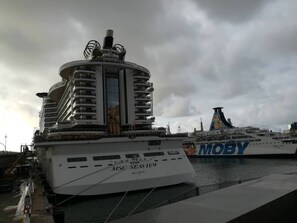 Ein großes Kreuzfahrtschiff liegt in einem Hafen festgemacht, mit der Aufschrift MSC Seaview an der Seite.