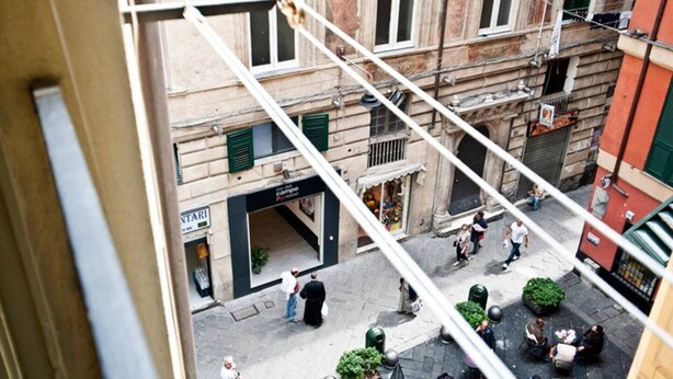 Une scène de rue en milieu urbain, avec un bâtiment dont la devanture porte l’inscription « INTARI ».
