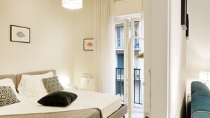 Een slaapkamer met een bed, nachtkastje en een raam.