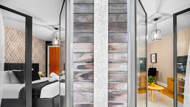 Un dormitorio moderno con cama, mesita de noche y armario.