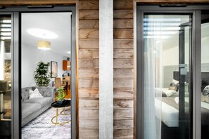 A modern interior with a sofa, a plant, and a dining area.
