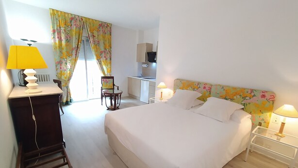 A bedroom with a bed, bedside tables, a desk, and a chair. - Appart'hotel Le Saint Antoine - Le Studio Confort en Centre Ville (Albi)