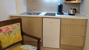 A compact kitchenette with a microwave, toaster, kettle, and a small sink. - Appart'hotel Le Saint Antoine - Le Studio Confort en Centre Ville (Albi)