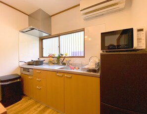 A compact kitchen with a sink, stove, microwave, and cabinets.