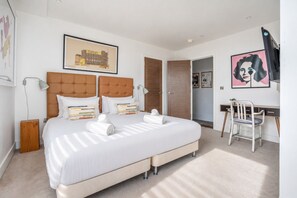 Ein Hotelzimmer mit einem großen Bett, einem Schreibtisch und einem Sessel.