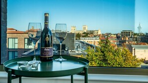 A table with a bottle of wine and two glasses on a balcony overlooking a cityscape. - Cityscape @ Ryedale House -  a family break that sleeps 4 guests  in 2 bedrooms (York)
