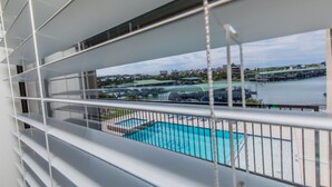 Un balcón con vista a una piscina y un puerto deportivo.