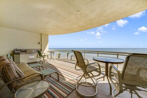 A balcony with a sofa, chairs, and a small table, overlooking the ocean. - WOW! Gorgeous Oceanfront Luxury Condo (Daytona Beach)